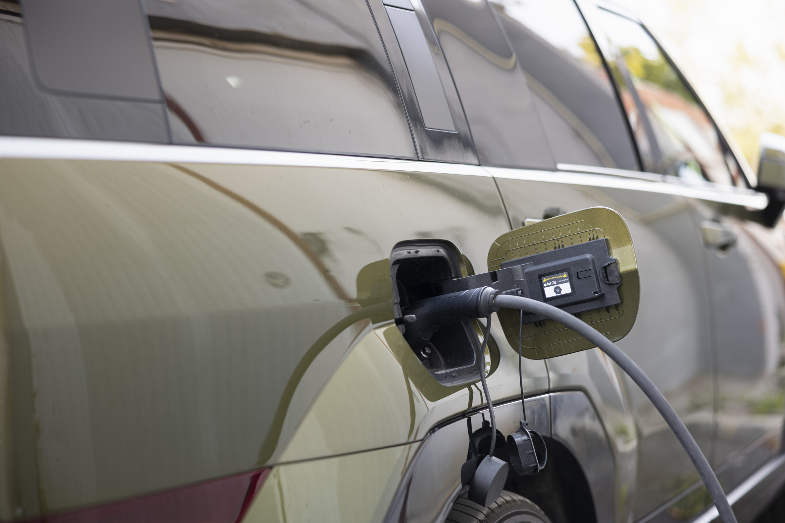 Close up shot of EV plug connected to electric car